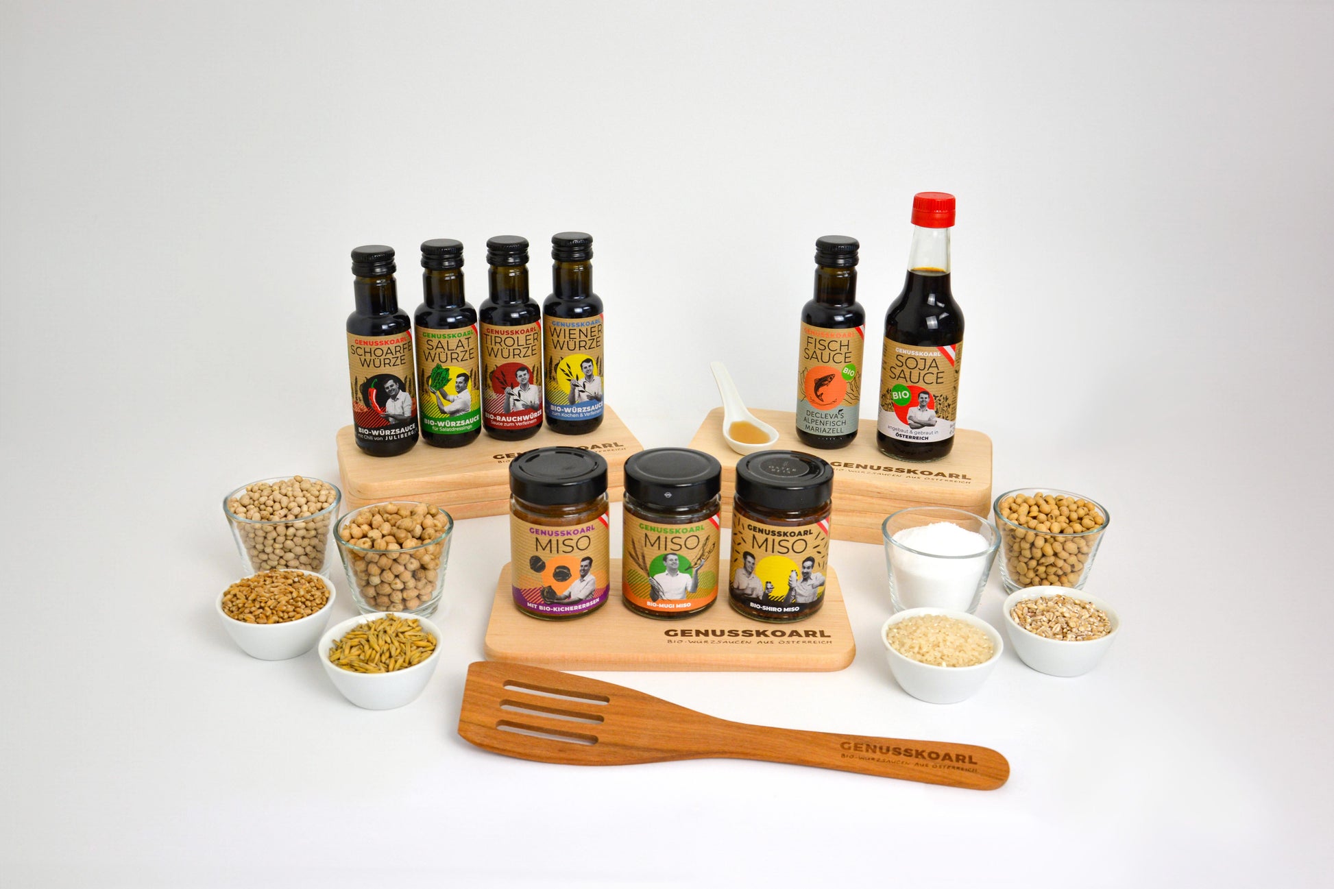 Genusskoarl Sortiment: mehrere Glasflaschen mit Sojasauce, Bio-Würzsauce und Miso-Gläser.