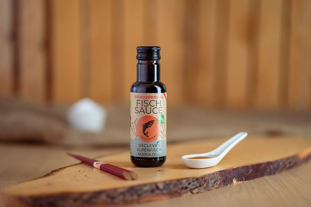 Würzsauce Genusskoarl Bio-Fischsauce in einer 100 ml Flasche auf Holzbrett