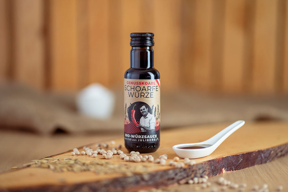 Würzsauce Genusskoarl Bio-SchoarfeWuerze in einer 100 ml Flasche auf Holzbrett