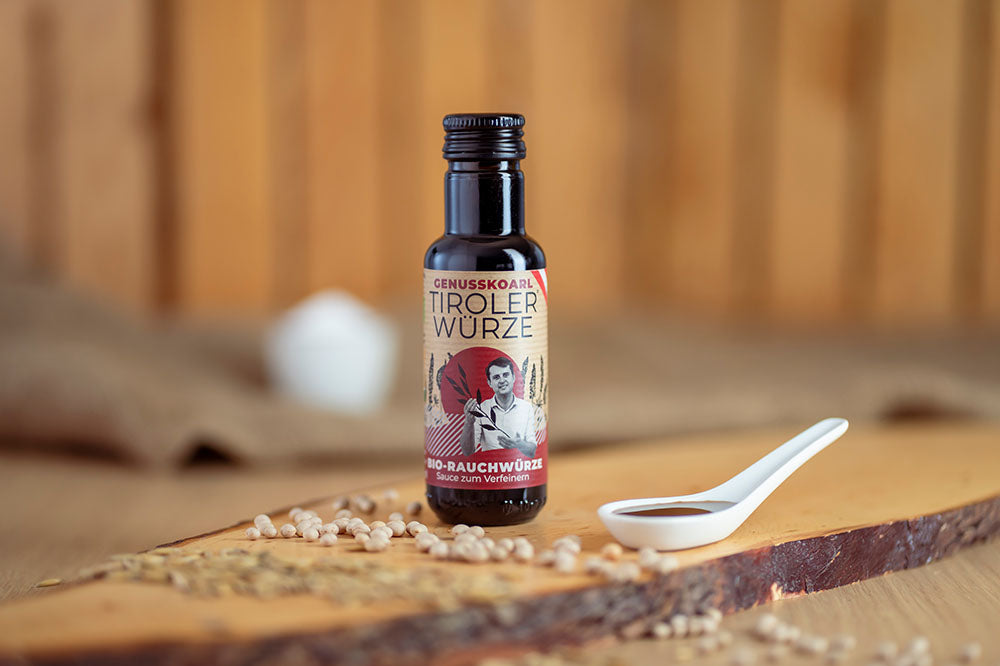 Würzsauce Genusskoarl Bio-TirolerWuerze in einer 100 ml Flasche auf Holzbrett